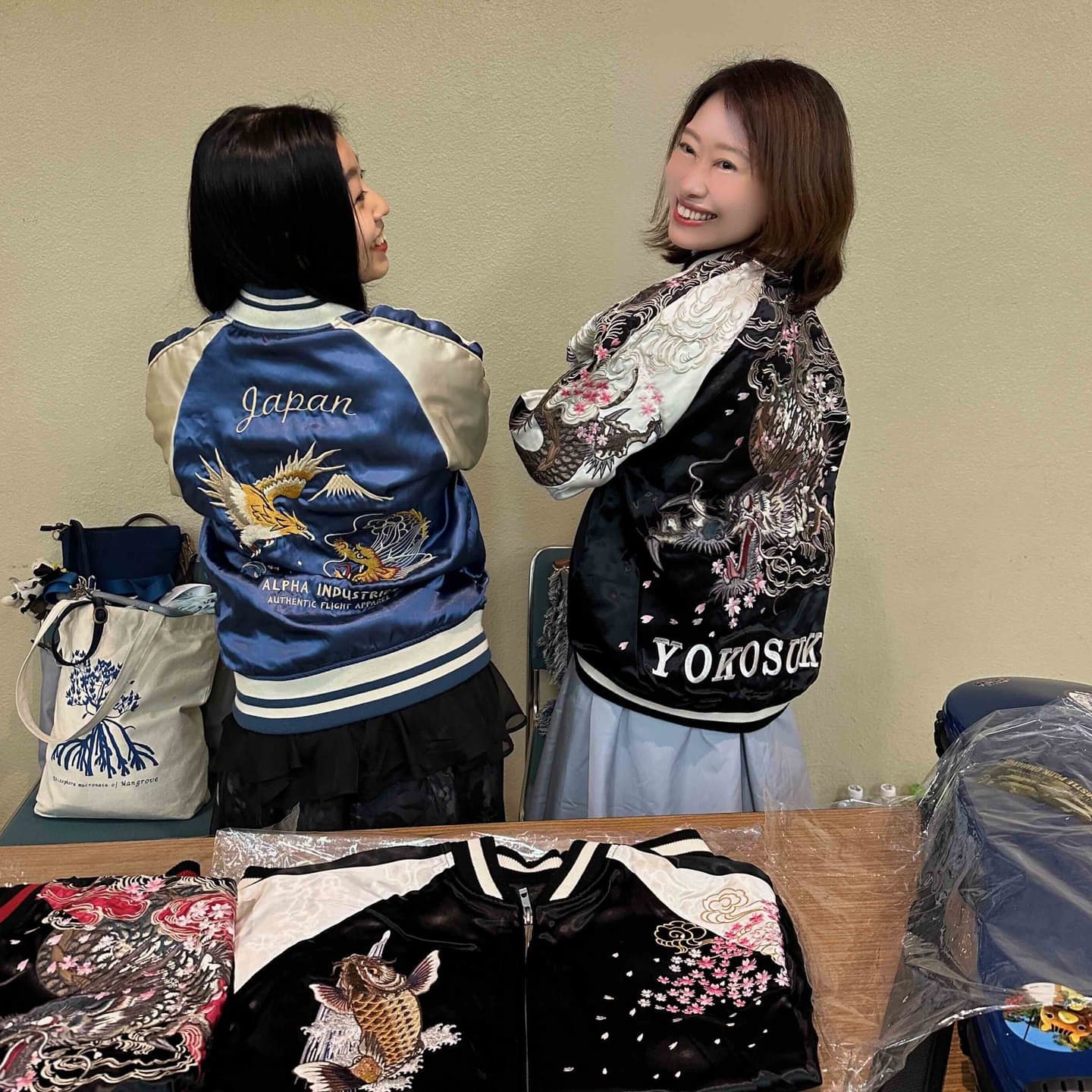 スカジャンを纏い笑顔でポーズを決めるNamiさん。夢を歌にのせるディズニー系シンガーとしても観光大使としても輝く存在。スカジャン姿でヴァイオリンを構える石川倫歌さん。クラシックと沖縄文化を融合させた音楽で魅せる新時代の観光大使。